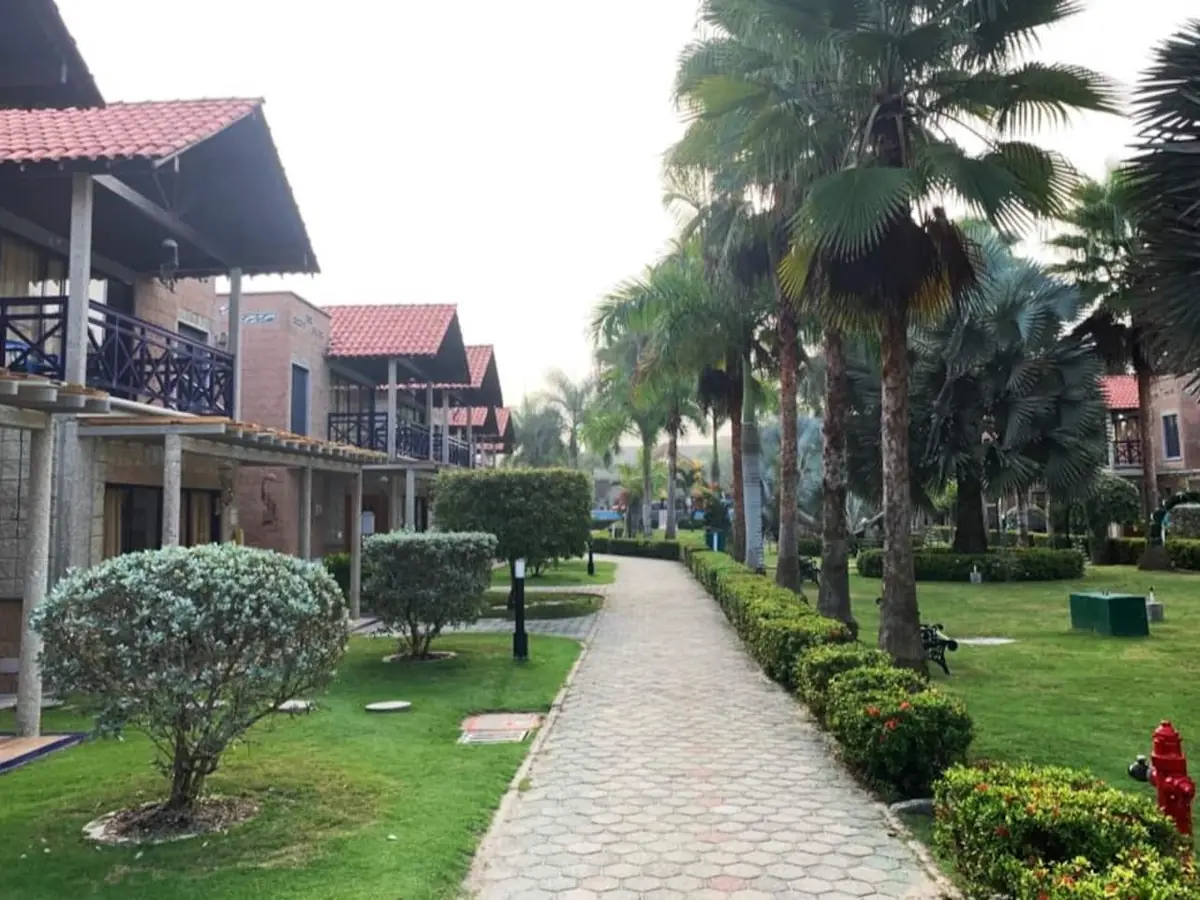 Cabañas de dos niveles y sendero entre jardines del condominio Palmacaoba (zona común)