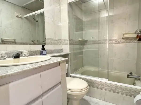 Baño con tina, ducha y mueble de lavamanos