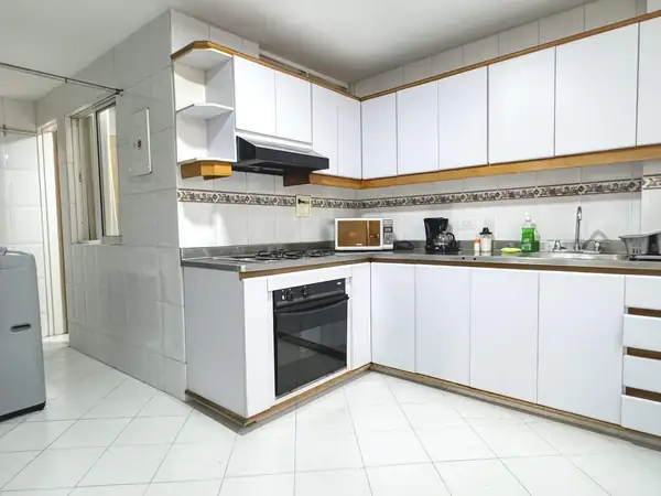 Cocina blanca con estufa, horno, microondas y cafetera