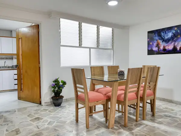 Comedor con la puerta de la cocina al fondo