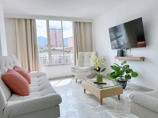 Sala con televisor, mesa de centro y ventanal