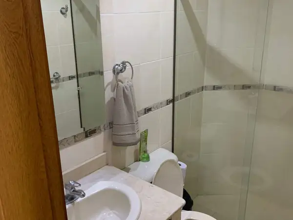 Baño con ducha de vidrio y lavamanos