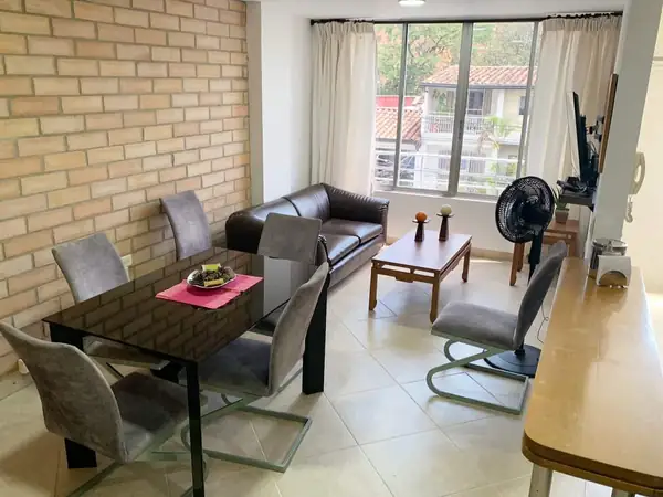 Comedor y sala junto a la ventana, con pared de ladrillo
