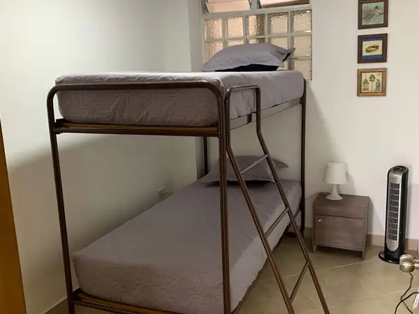Habitación con camarote de dos puestos y mesa de noche
