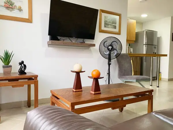 Sala con televisor, mesa de centro y ventilador