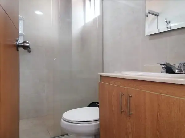 Baño con ducha, sanitario y mueble de lavamanos