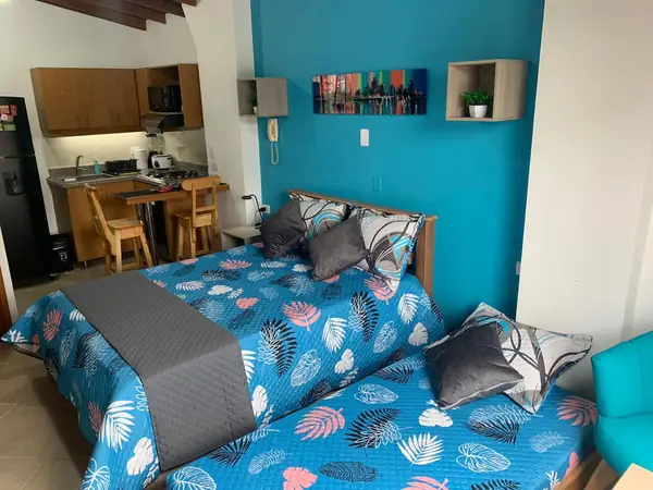 Cama doble y cama nido con la cocina y la barra comedor al fondo