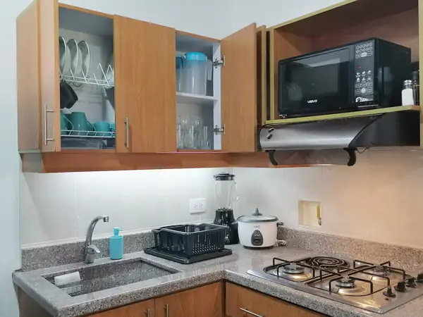 Cocina con estufa de gas, microondas, licuadora y arrocera