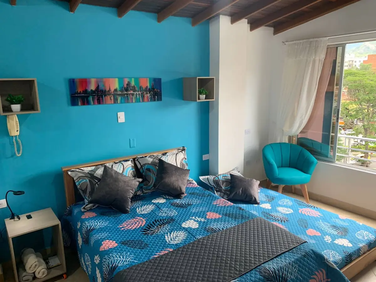Estudio 501 Acacias en Laureles, Medellín, con cama doble, cama nido y sillón junto a la ventana