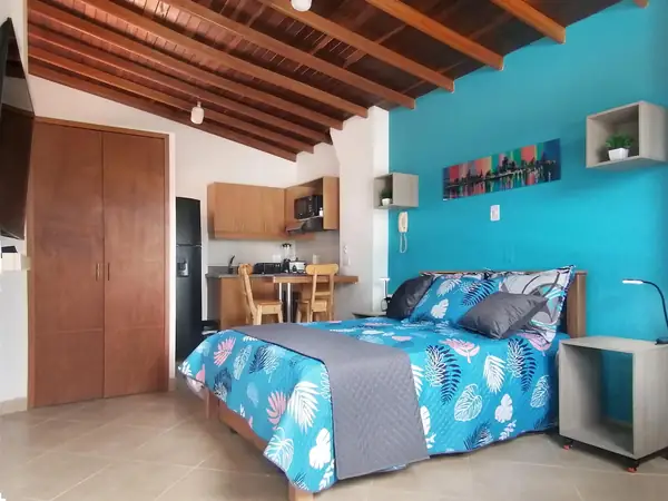 Estudio con cama doble, closet y cocina al fondo