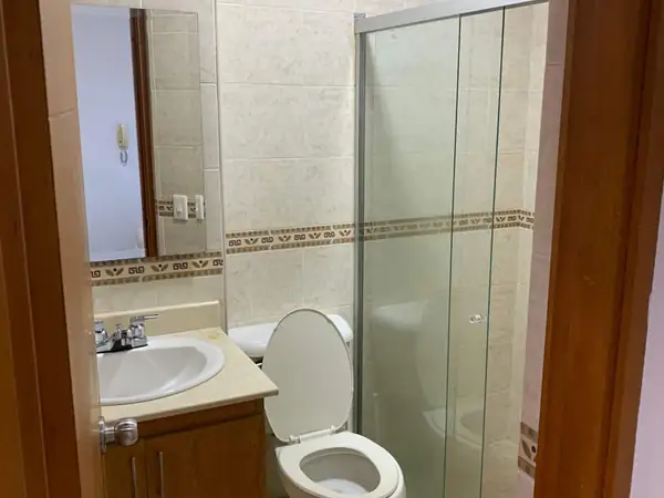 Baño con ducha de vidrio, sanitario y lavamanos