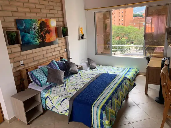 Cama doble junto a la ventana con vista a los edificios