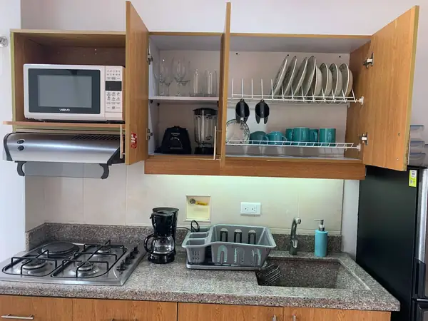 Alacena con platos, vasos, licuadora y microondas