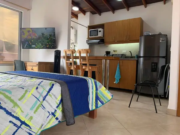 Escritorio, televisor y cocina con barra