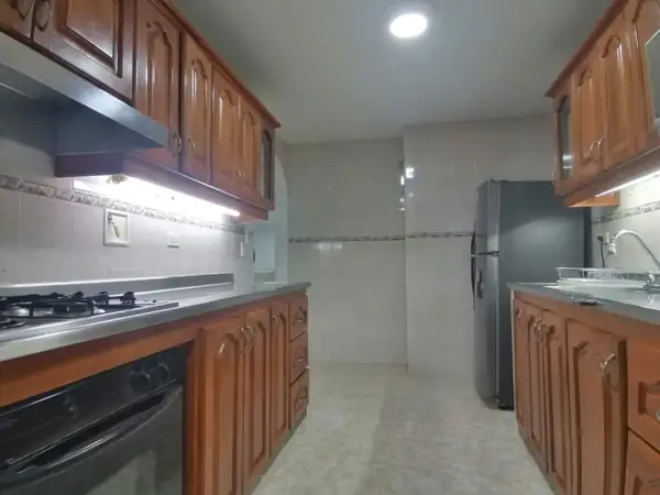 Cocina con estufa, horno y gabinetes de madera