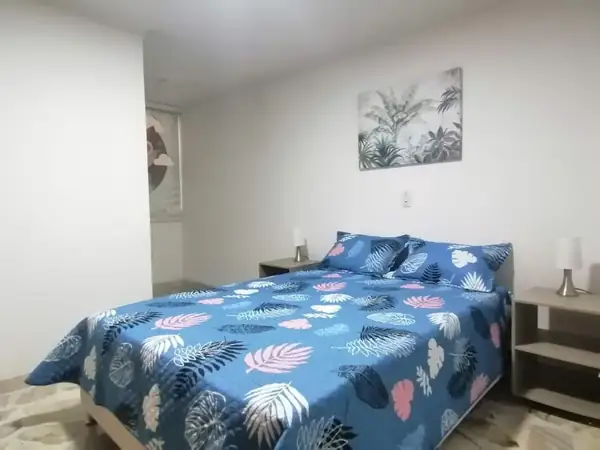 Habitación con cama doble y mesas de noche