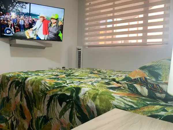 Habitación con cama queen y televisor