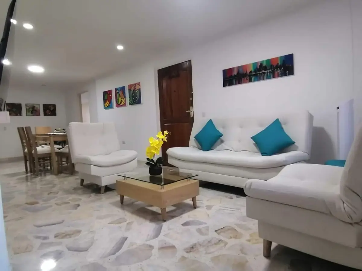 Sala del apartamento 401 San Antonio en Laureles, Medellín, con sofás blancos y el comedor al fondo