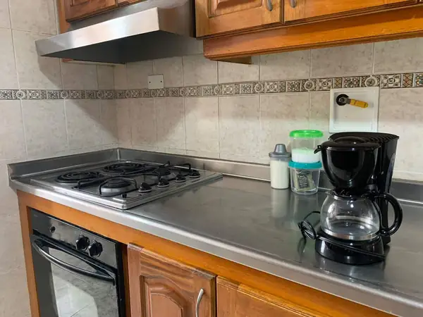 Estufa eléctrica, horno y cafetera en la cocina