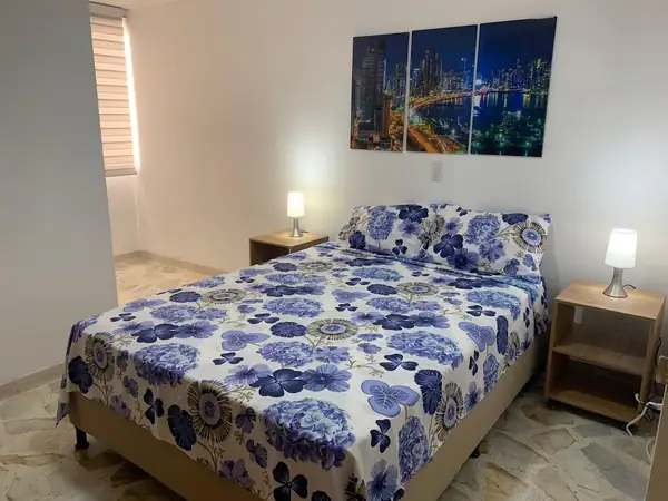 Habitación con cama y dos mesas de noche con lámparas