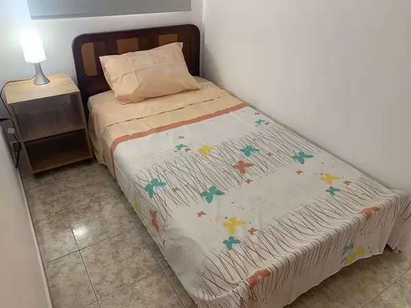 Habitación con cama sencilla y mesa de noche