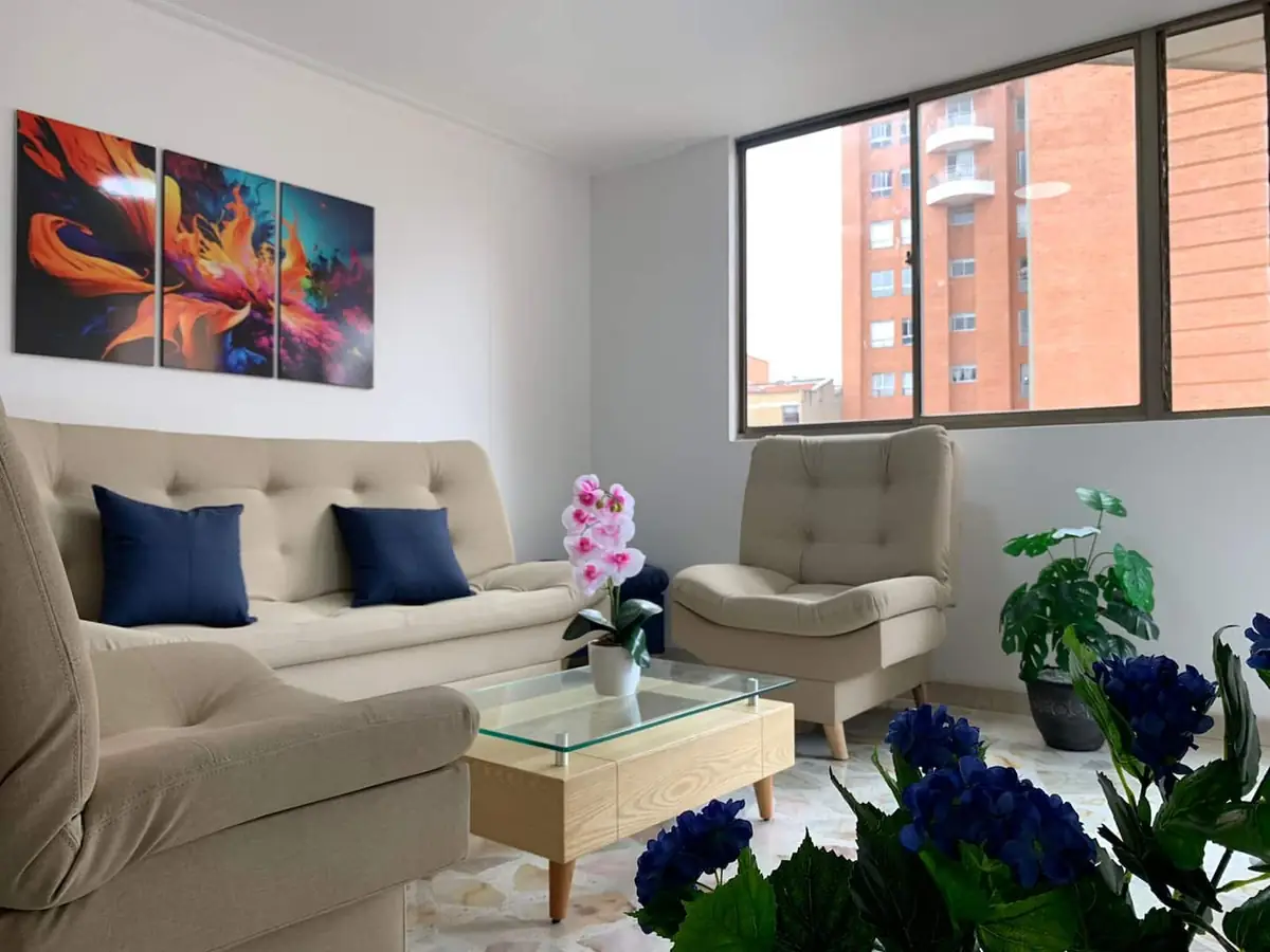 Sala del apartamento 601 San Antonio en Laureles, Medellín, con ventanal y sofás
