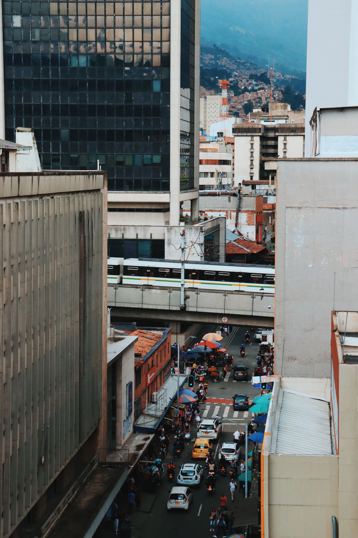 Calle urbana de Medellín Colombia con peatones y vida local — comparativa Laureles vs El Poblado
